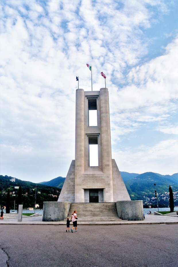 Monumento ai caduti – spomenik žrtvam 1. svetovne vojne je delo racionalističnega arhitekta Giuseppeja Terragnija (1904–1943).