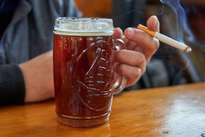 Cigarete in alkohol: zakaj pijača vpliva na željo po kajenju