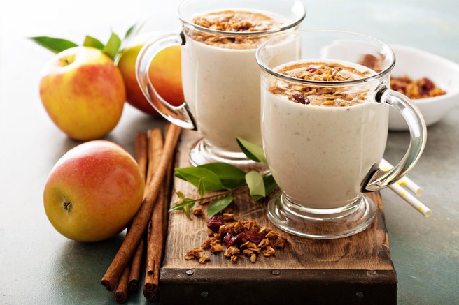 Dva smoothija na pultu ob cimetu in jabolkih.