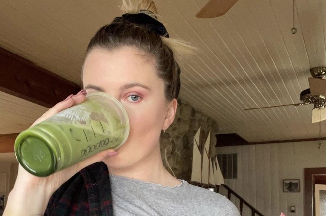 Ženska pije zelen smoothie.