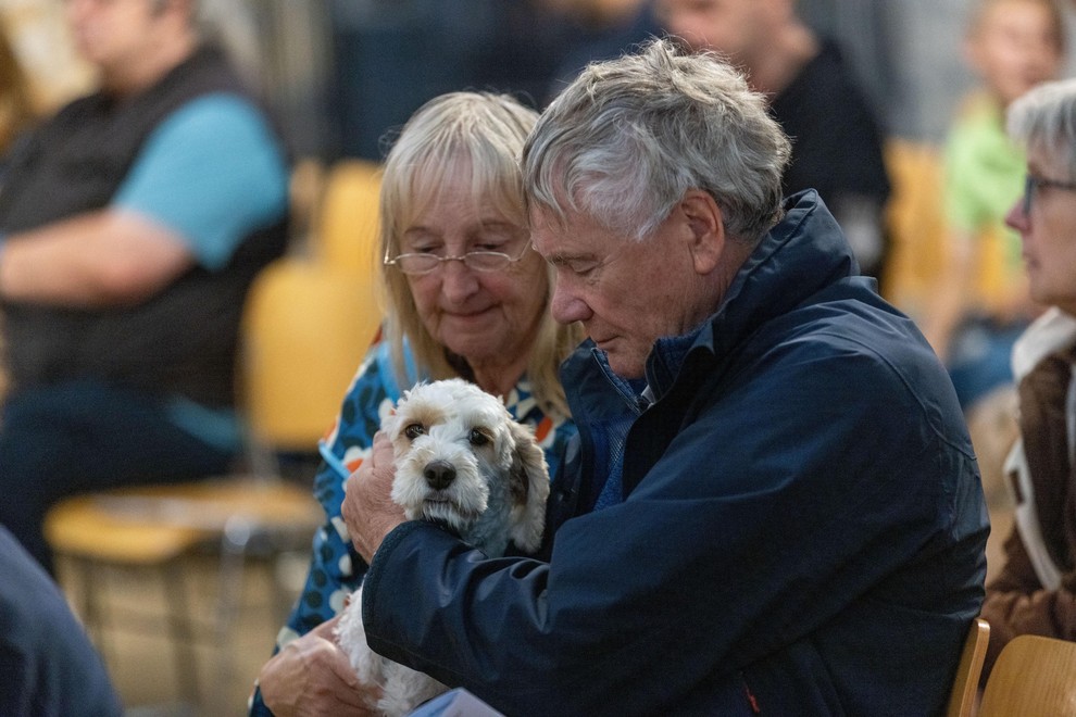 Starejši moški in ženska božata psa.
