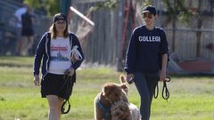 Dve mladi ženski sprehajata psa.