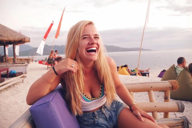 Nasmejana ženska na plaži.