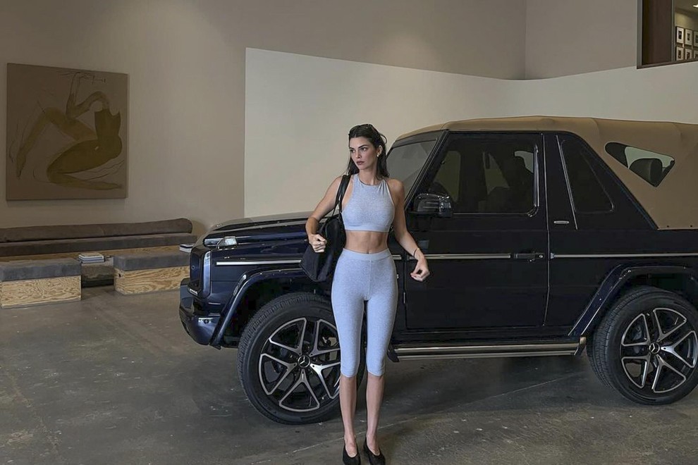 Ženska pozira ob avtomobilu